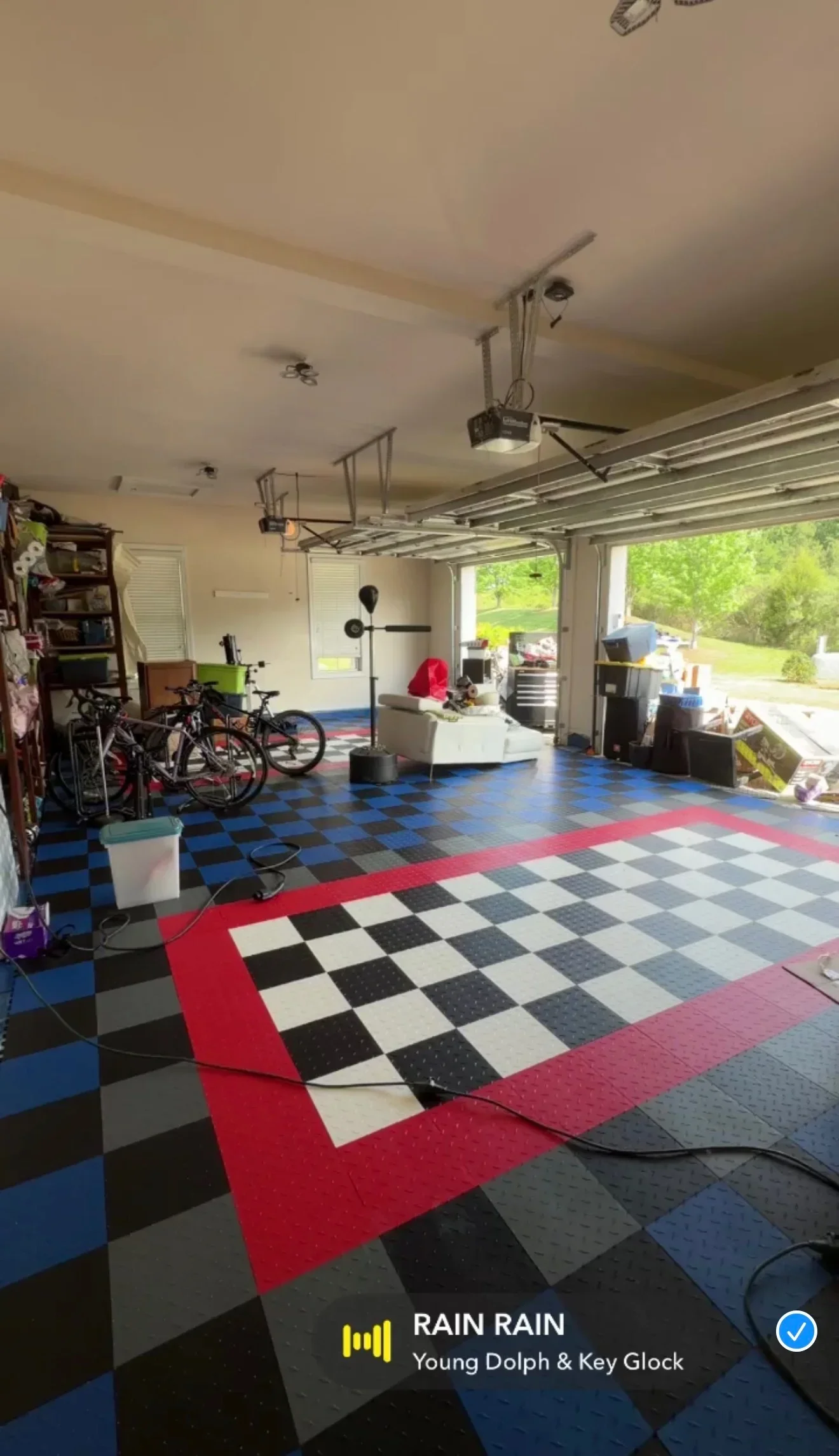 Interlocking modular garage flooring with red, black, white, and blue geometric tile pattern