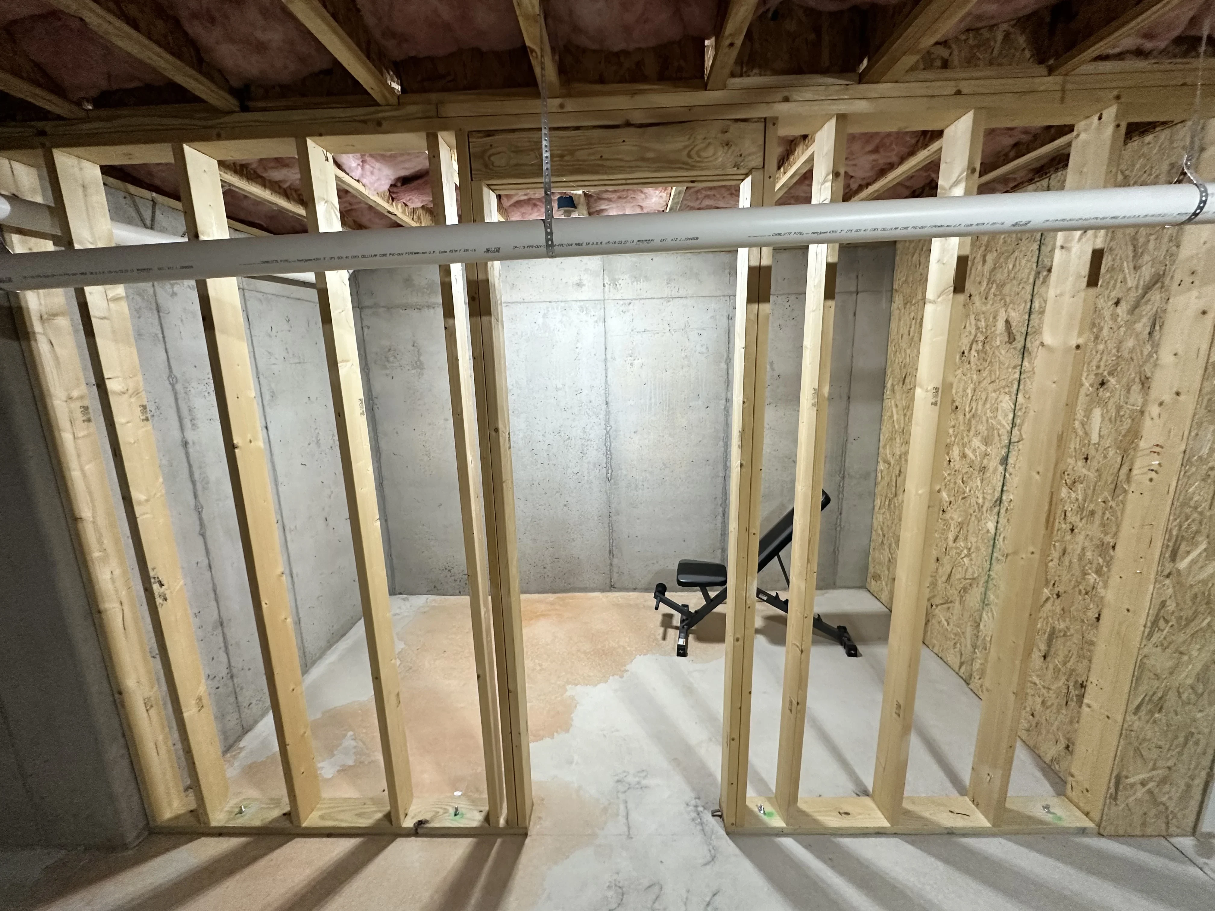 Interior framing with wood studs, OSB sheathing, metal conduit, and drywall substrate