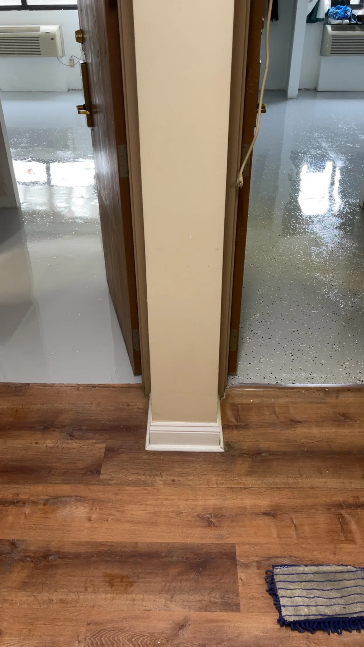 Polished concrete floor with aggregate finish and wood transition edge in commercial interior