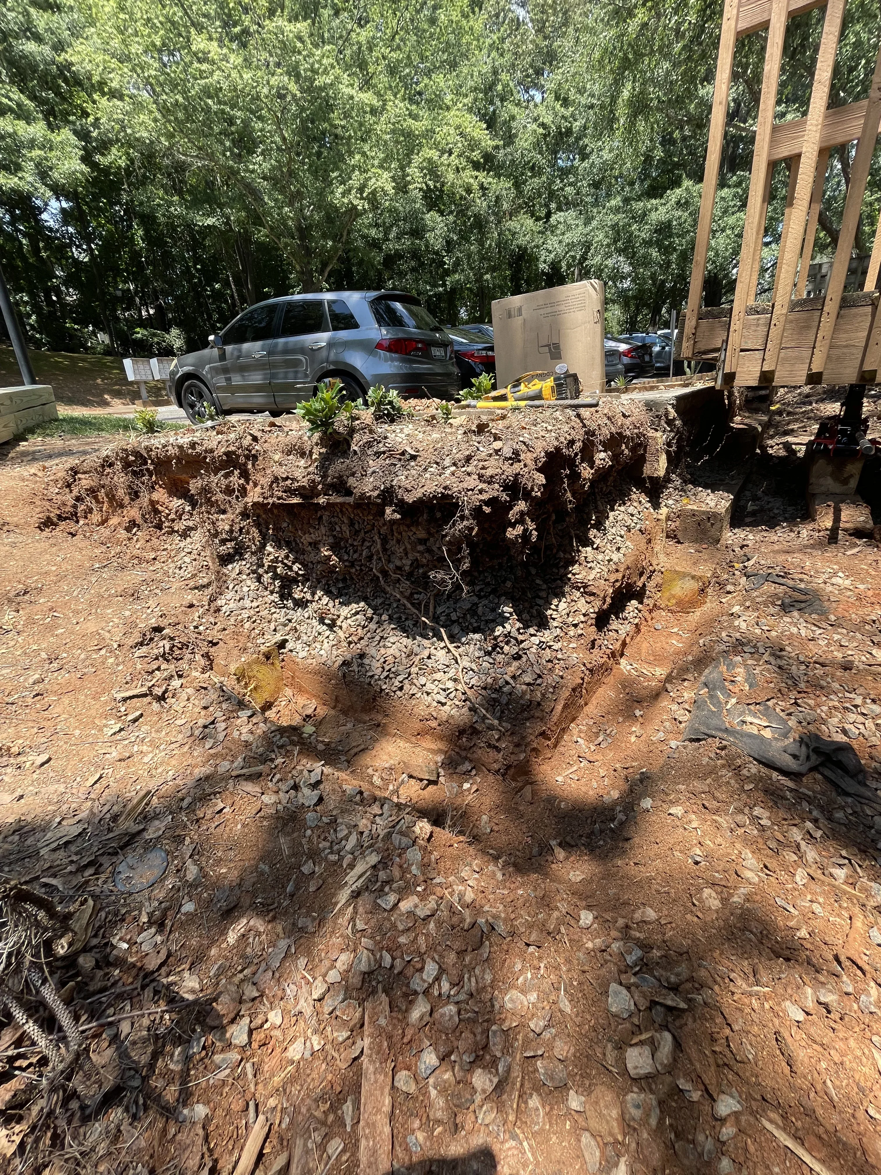 Excavated septic system installation pit with rocky clay soil and installed tank